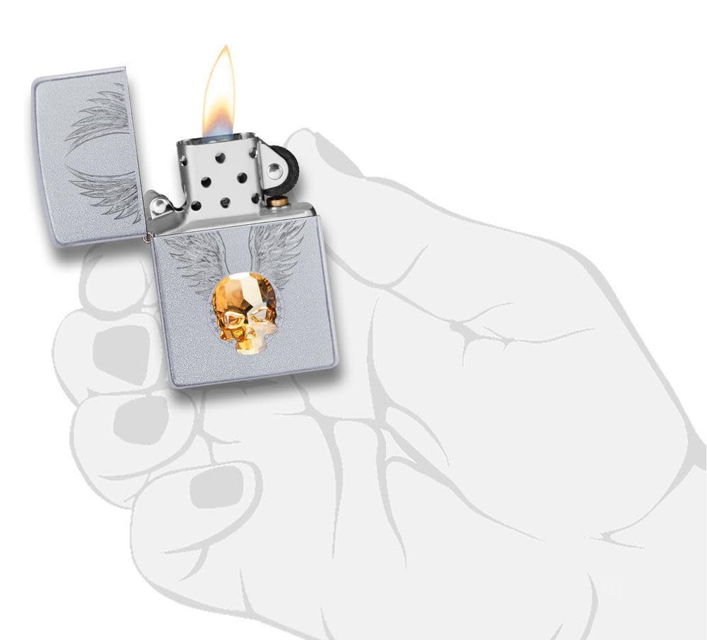 Front view of the Gold Skull Design Lighter with Skull Emblem in hand, open and lit